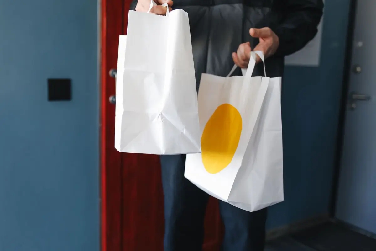 Pessoa carregando sacolas de compras