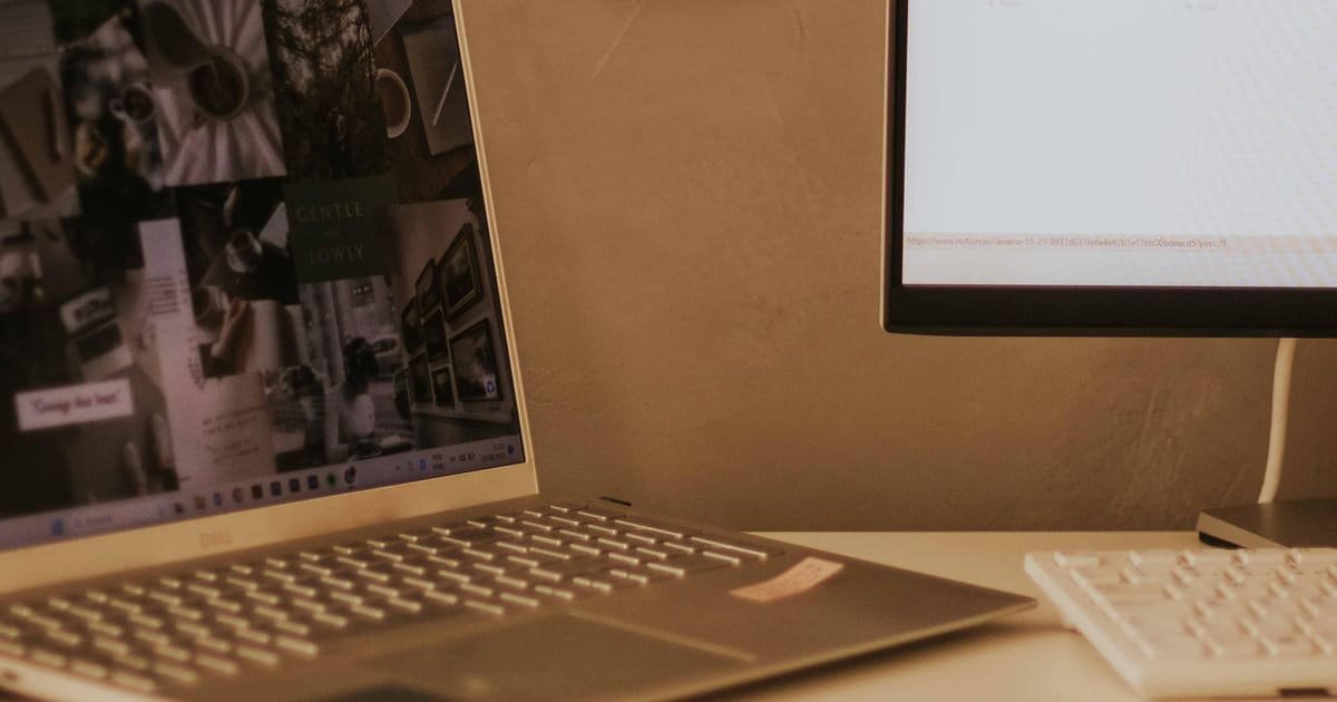 Notebook numa mesa com recados colados na parede