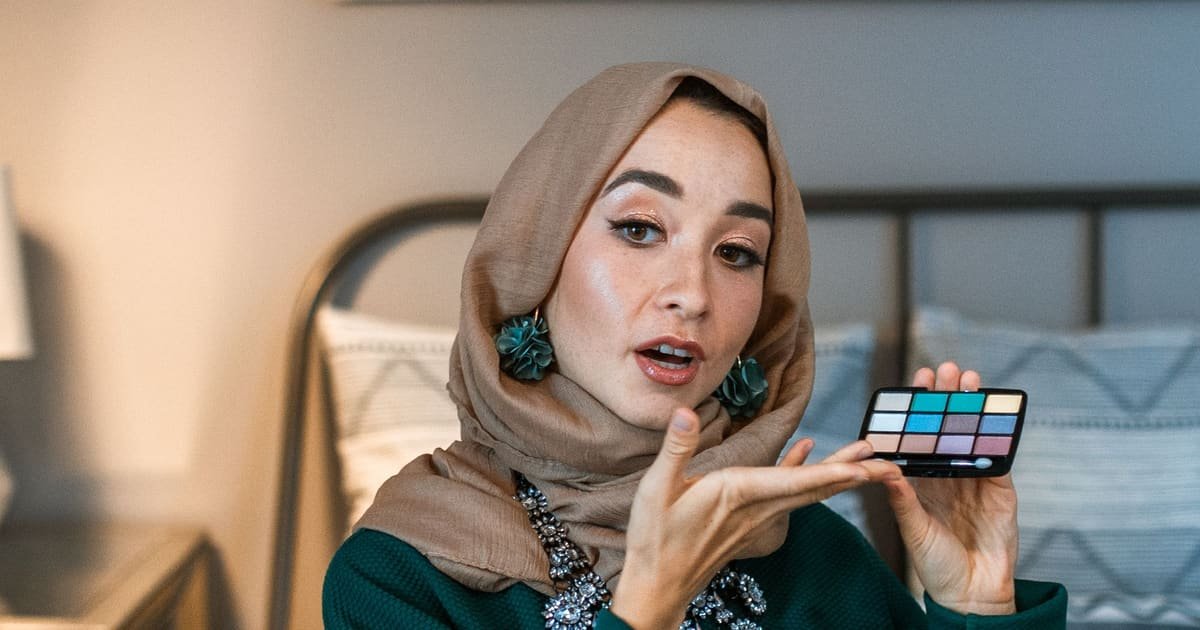Criadora mostrando uma paleta de maquiagem para a câmera