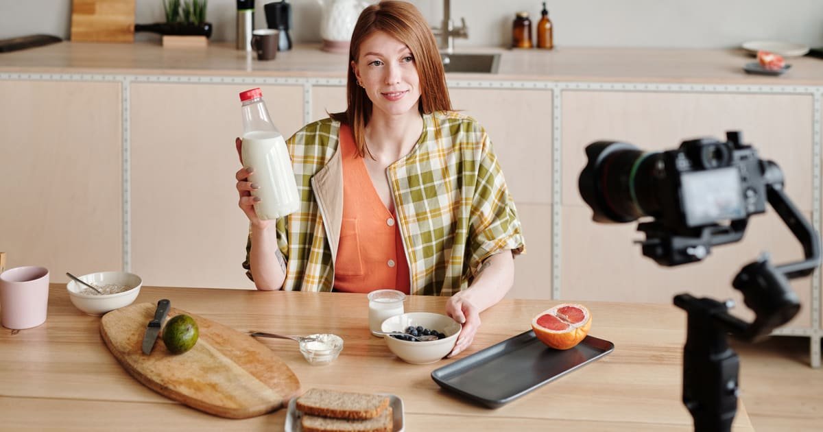 Criadora mostra um produto para a câmera na cozinha