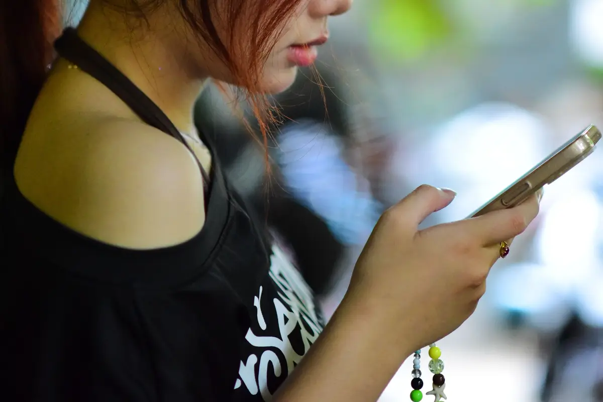 Mulher olhando o celular ao ar livre