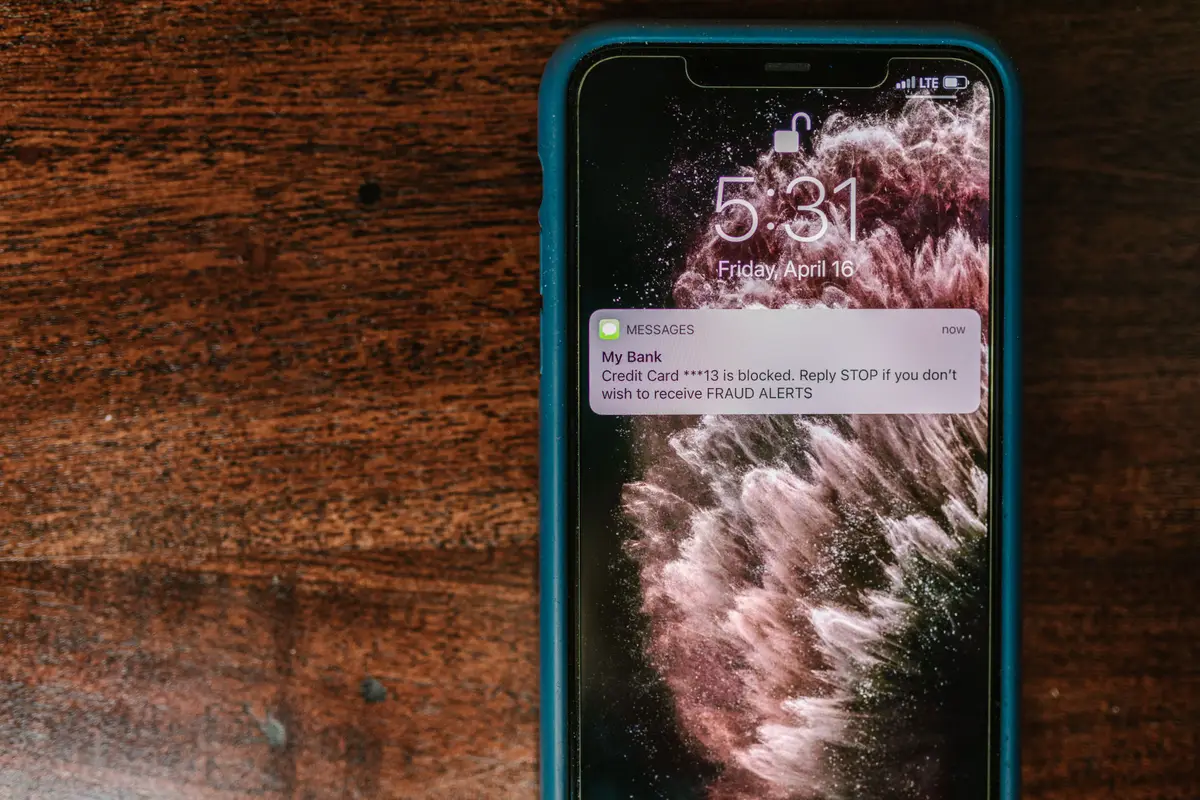 Celular sobre a mesa de madeira com uma notificação na tela