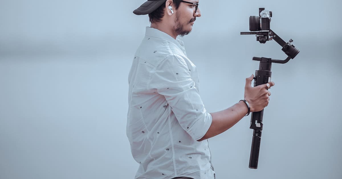 Homem gravando com o celular num estabilizador