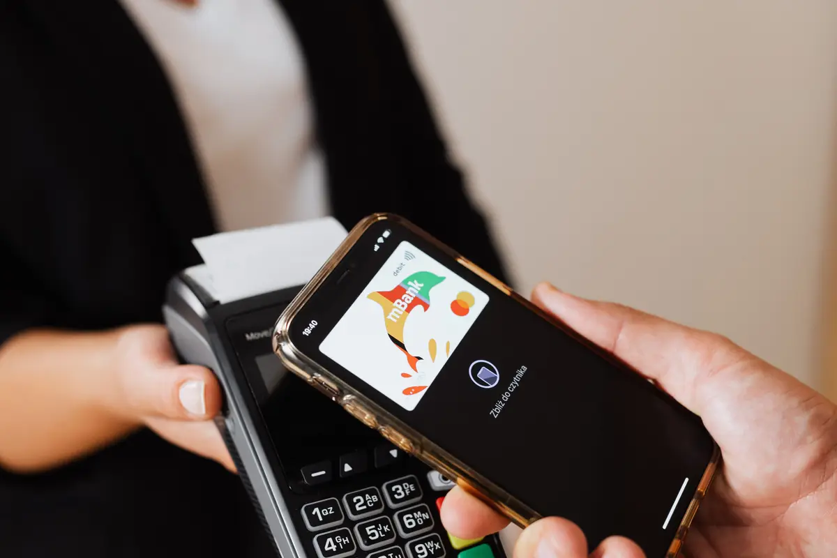 Cliente aproximando o celular da maquininha da vendedora
