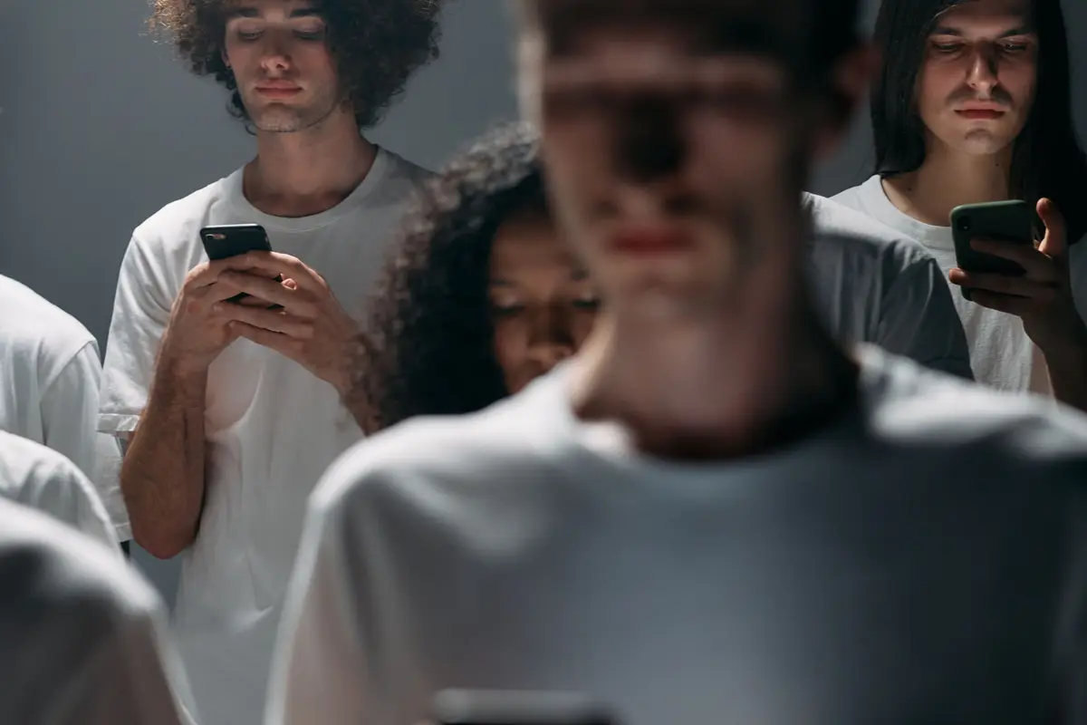 Grupo de pessoas de camiseta branca olhando o celular