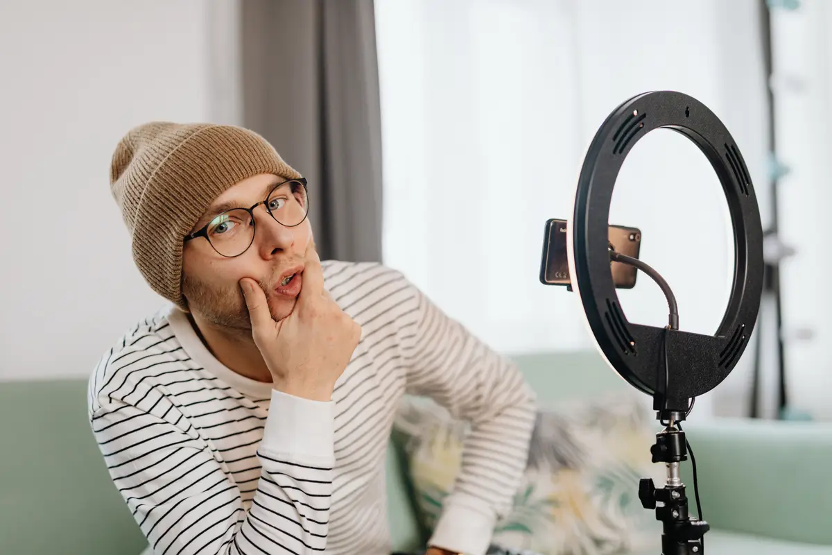 Criador de gorro pensando, sentado diante de um ring light