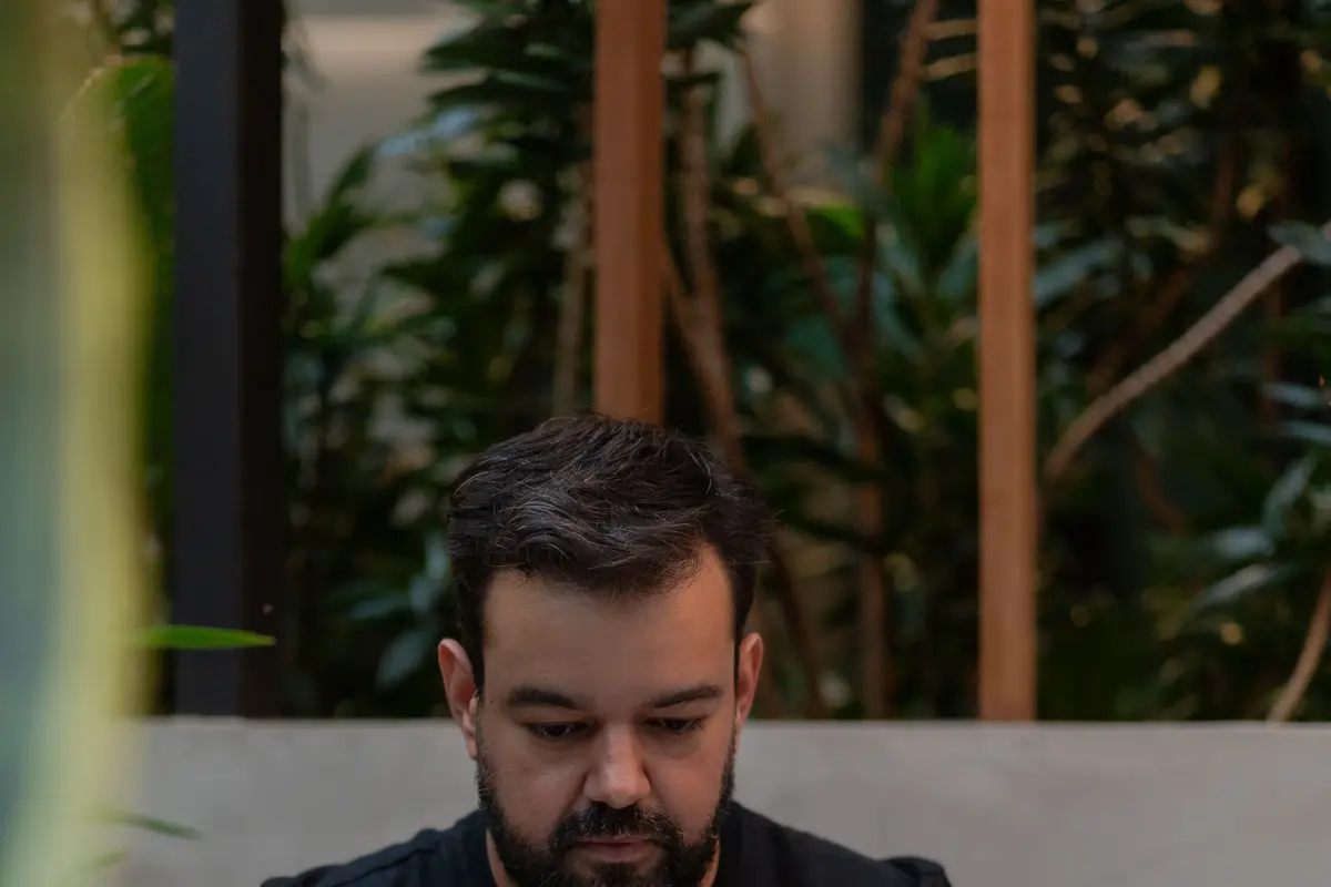 Homem trabalhando no notebook num café ao ar livre